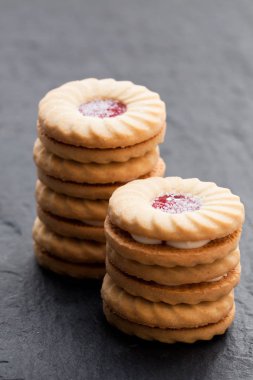 Krem ve siyah taş zemin üzerine reçel ile yığılmış kurabiye Bisküvi sandviç 