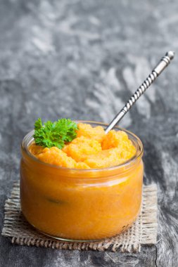 Ahşap masa üzerinde cam kavanozlara turuncu sebze püresi 