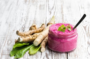 Ahşap masa üzerinde küçük cam kavanoza baharatlı horseradish sos 