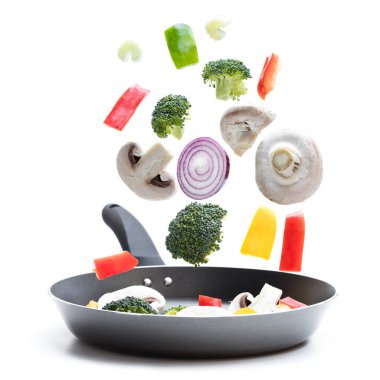 Uçan beyaz izole bir tava içine yemek için taze sebze hazır 