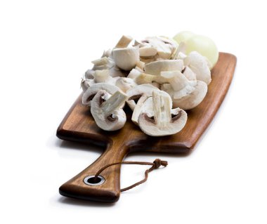 Ham dilimlenmiş mantar ve soğan üzerinde beyaz izole kesme tahtası üzerinde. 