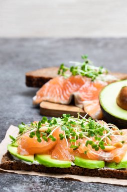 Somon ve avokado çavdar ekmeği sandviç gri masada 