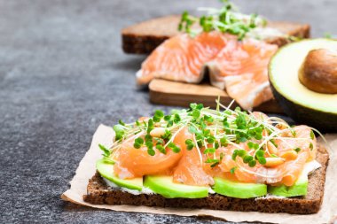 Somon ve avokado çavdar ekmeği sandviç gri masada 