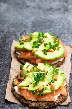 Somon ve avokado çavdar ekmeği sandviç gri masada 