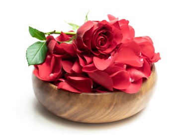 Ahşap masa üzerinde beyaz izole kırmızı gül yaprakları yığını 