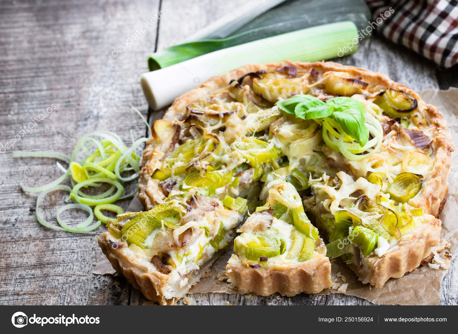 Leek tart with bacon and cheese on wooden table Stock Photo by ©Lena