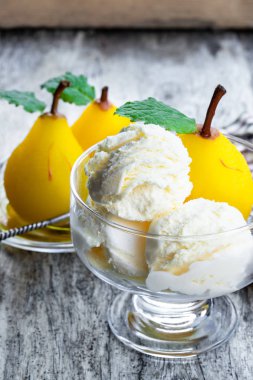 Ahşap masa üzerinde vanilyalı dondurma ile tatlı Haşlanmış armut 