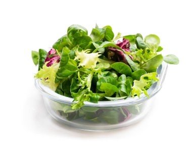 Karışık salata yaprakları üzerinde beyaz izole açık cam kase 