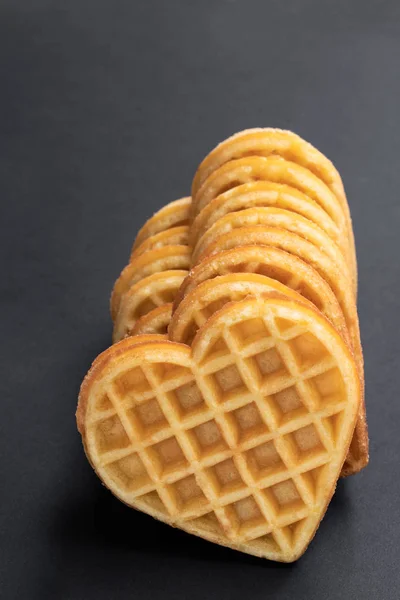 Stacks of heart shaped waffles on black background — Stock Photo, Image