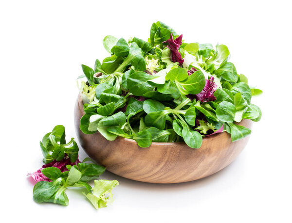 Mixed salad leaves in wooden bowl isolated on white 
