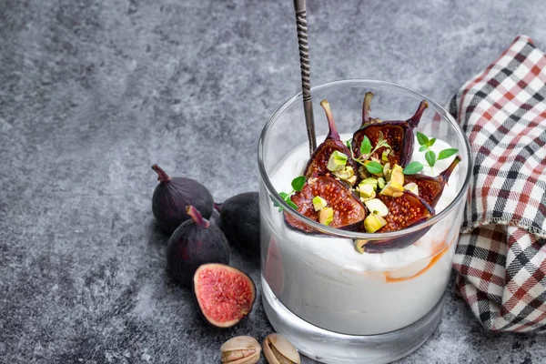 Домашний йогурт с инжиром на гриле и фисташкой на сером столе — стоковое фото