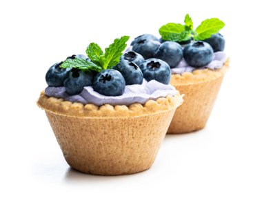 Mavi krem ve taze yaban mersini beyaz izole mini tart 