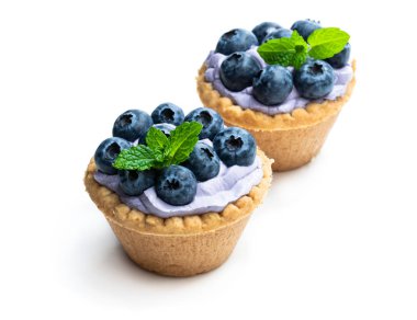 Mavi krem ve taze yaban mersini beyaz izole mini tart 