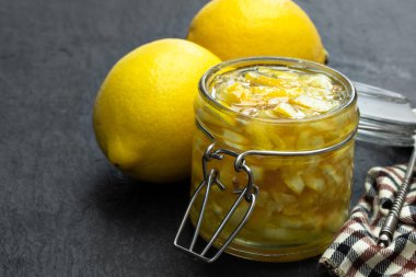 Siyah taş arka plan üzerinde cam kavanozda Limon reçeli 