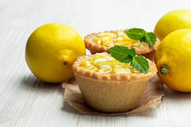 Beyaz ahşap masa üzerinde jöleli limon ile yumurta muhallebi tart 