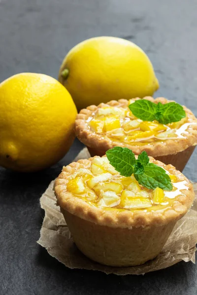 Siyah taş arka plan üzerinde jöleli limon ile yumurta muhallebi tart 
