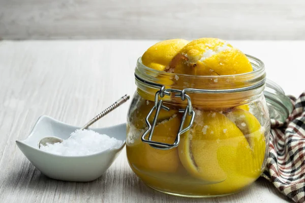 摩洛哥腌制柠檬在玻璃罐的白色木表 — 图库照片