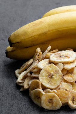 Taş arka planda izole edilmiş ev yapımı kurutulmuş muz cipsi 