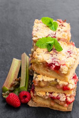 Siyah taş arka plan üzerinde ahududu ile ev yapımı rhubarb tart 