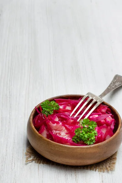 Салат с капустой и свеклой в деревянной чаше на белом столе — стоковое фото
