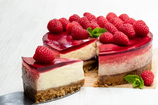 Zelfgemaakte Cheesecake met frambozen gelei op witte houten tafel — Stockfoto