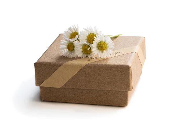 Caja de regalo casera hecha de papel marrón con flores pequeñas silvestres aisladas en blanco —  Fotos de Stock
