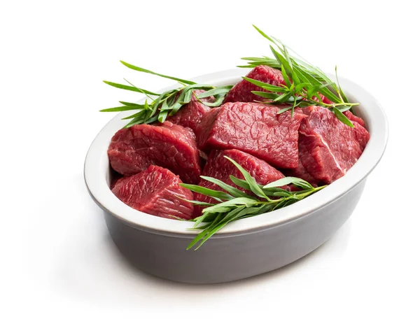 Sliced raw beef with tarragon herb in ceramic bowl isolated on white — Stock Photo, Image