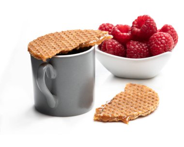 Taze ahududu ve beyaz izole kahve fincan ile Erimiş Hollanda karamel waffle 