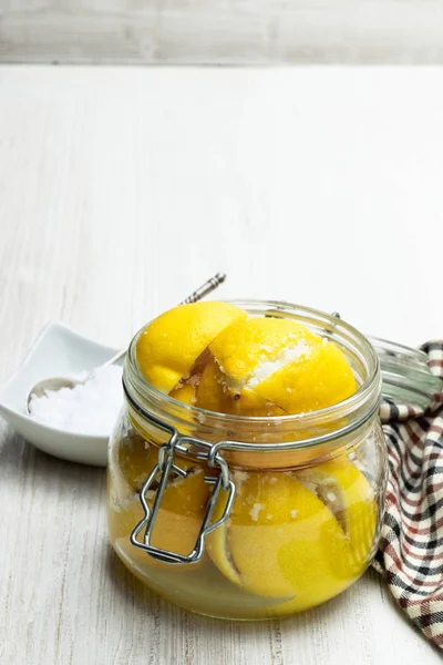 Fas korunmuş tuzlu limon cam kavanozda beyaz ahşap masa 