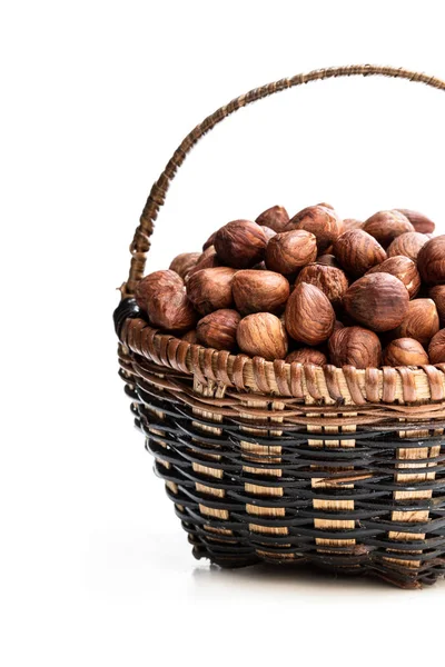 Pequeña cesta llena de granos de avellana aislados en blanco — Foto de Stock