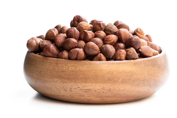 Beyaz üzerine izole fındık çekirdekleri dolu küçük ahşap plaka 