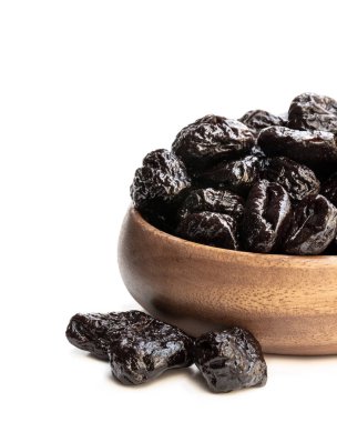 Beyaz izole kurutulmuş erik dolu küçük ahşap plaka 