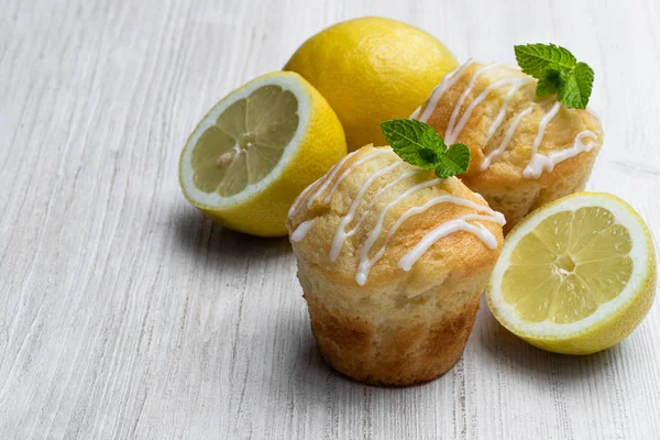 Domácí citronové muffiny na bílém dřevěném stole — Stock fotografie