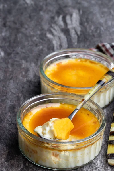 Closeup of creme brulee in glass jars on rustic wooden table — Stock Photo, Image