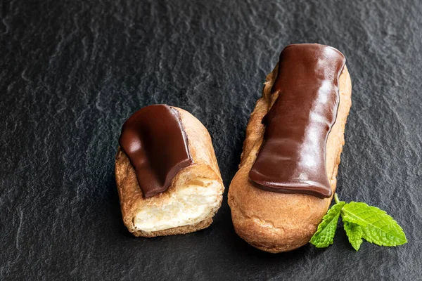Eclairs Cioccolato Sfondo Pietra Nera — Foto Stock