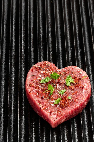Kalp şeklinde çiğ et ve ızgara tepsisinde baharatlar. Sağlıklı yaşam tarzı ya da et severler için organik gıda konsepti. 