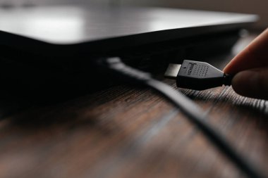 Adam HDMI kablosunu cihaza bağlıyor ve HDMI portuna yerleştiriyor.. 