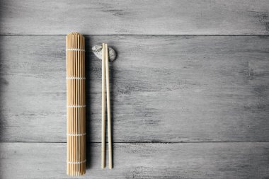 Yuvarlak ahşap arka plan manzaralı Çin yemekleri için hasırlar ve çubuklar. Asya çatal bıçak takımı.