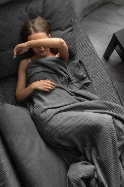 Güzel, beyaz bir kadın sabahları evdeki kanepede uyanıyor ve gözlerini hiç uyumadan ovalıyor.. 