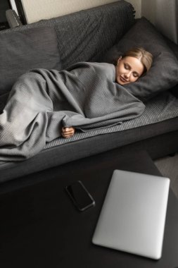 Güzel beyaz kadın evdeki kanepede uyuyor ve güzel rüyalar görüyor. Sağlıklı, iyi uykular..