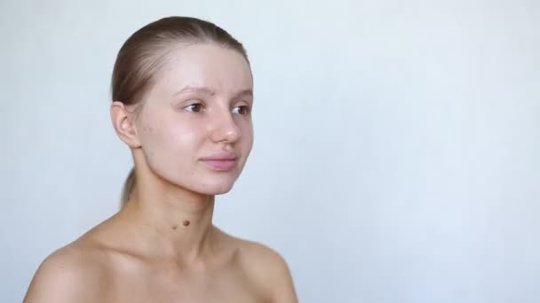 Frau trägt Feuchtigkeitscreme auf problematische Haut im Gesicht auf und lächelt — Stockvideo