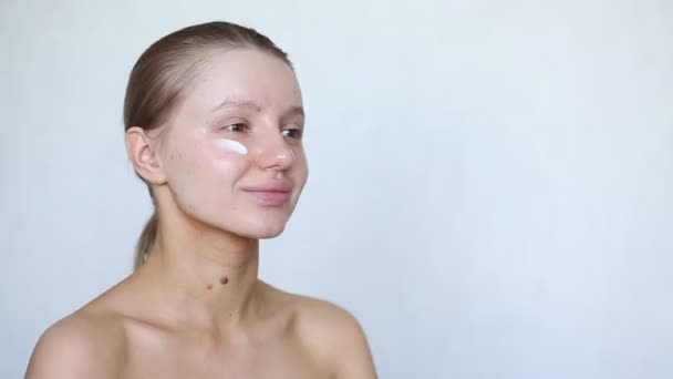 Hermosa mujer caucásica unta crema hidratante en la piel problema, sonrisas — Vídeo de stock