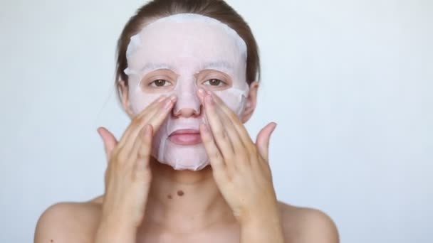 Mooi meisje zet een cosmetisch masker op haar gezicht. Gezonde gezichtshuid. — Stockvideo