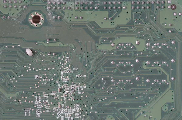 Old and dusty computer motherboard with resistors and connectors