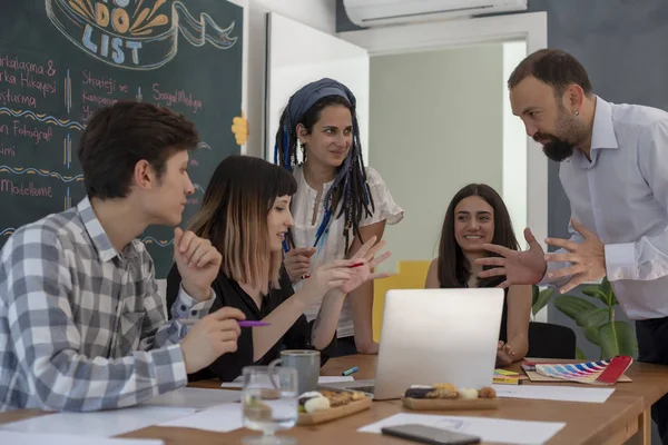 Smiling co workers standing in front of the table during present