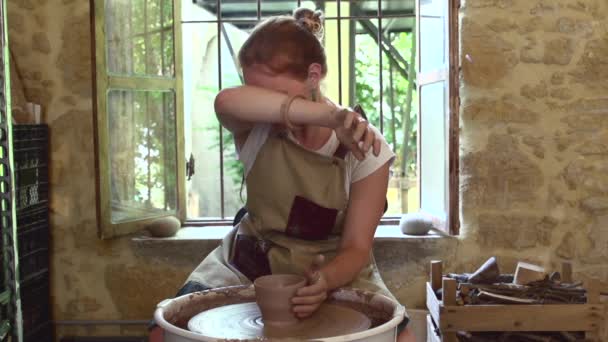 Vrouw Werkt Aan Potters Wiel Swipen Haar Voorhoofd Handen Sculpteert — Stockvideo