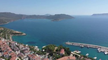Güzel mavi denizi ve gökyüzü ile Kaş Türkiye Kasabası ve limanının denize doğru hareket eden drone