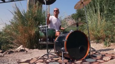 Adam doğada serin davul çalıyor. Etkileyici bir performans. 4K Düşük açılı orta vuruş.