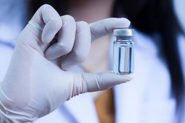 Doktorun, ilaç şişesinin kavramsal tıp bilimi araştırmasını gösteren yakın çekimi.