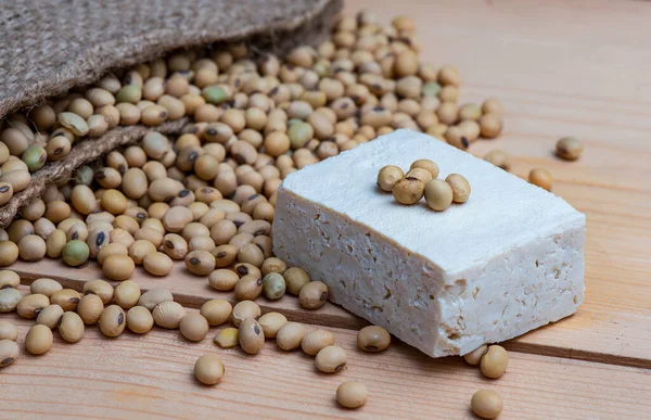 Flat view, yellow beans seed And tofu slices Manufactured from soybeans, placed on a wooden board